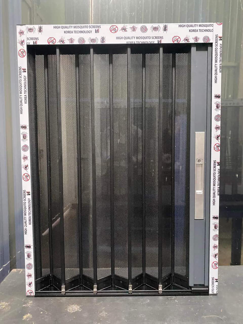 Cửa lưới xếp lá nhôm thực tế lắp đặt tại ban công, chống muỗi hiệu quả, mang lại không gian thông thoáng.