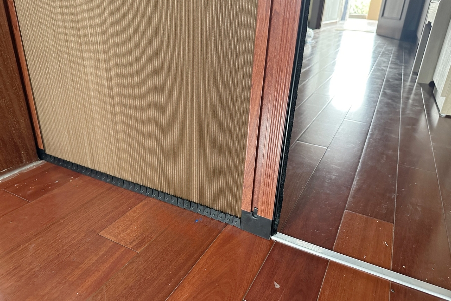 Vách ngăn tổ ong có khung giả vân gỗ và hệ thống ray xích dưới sàn.