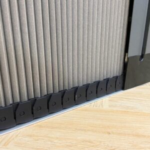 Cận cảnh chi tiết ray xích màu đen của vách ngăn rèm tổ ong màu xám, lắp đặt trên sàn