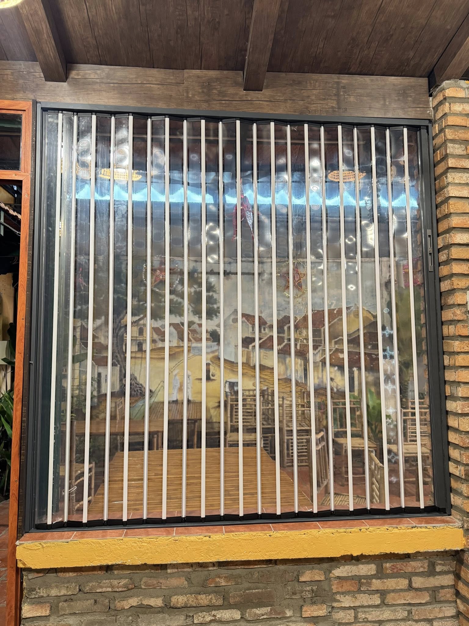 Cửa xếp lá nhựa polycarbonate ngăn lạnh giữa phòng khách và bếp.