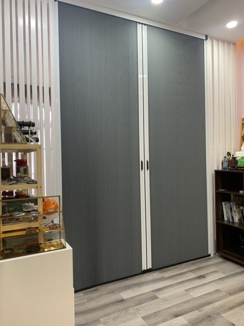 Hệ cửa xếp tổ ong không ray (hệ xích) màu vân gỗ, phù hợp cho cửa đi lại chính.
